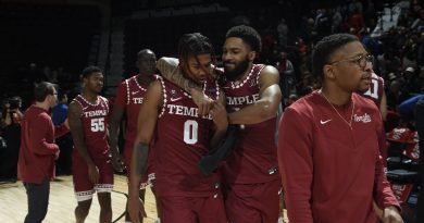 Damian Dunn embraces Khalif Battle surrounded by their teammates, celebrating the win over Rutgers and Battle's impressive performance.