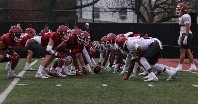 Temple's cherry and white teams line up against each other at the line of scrimmage.