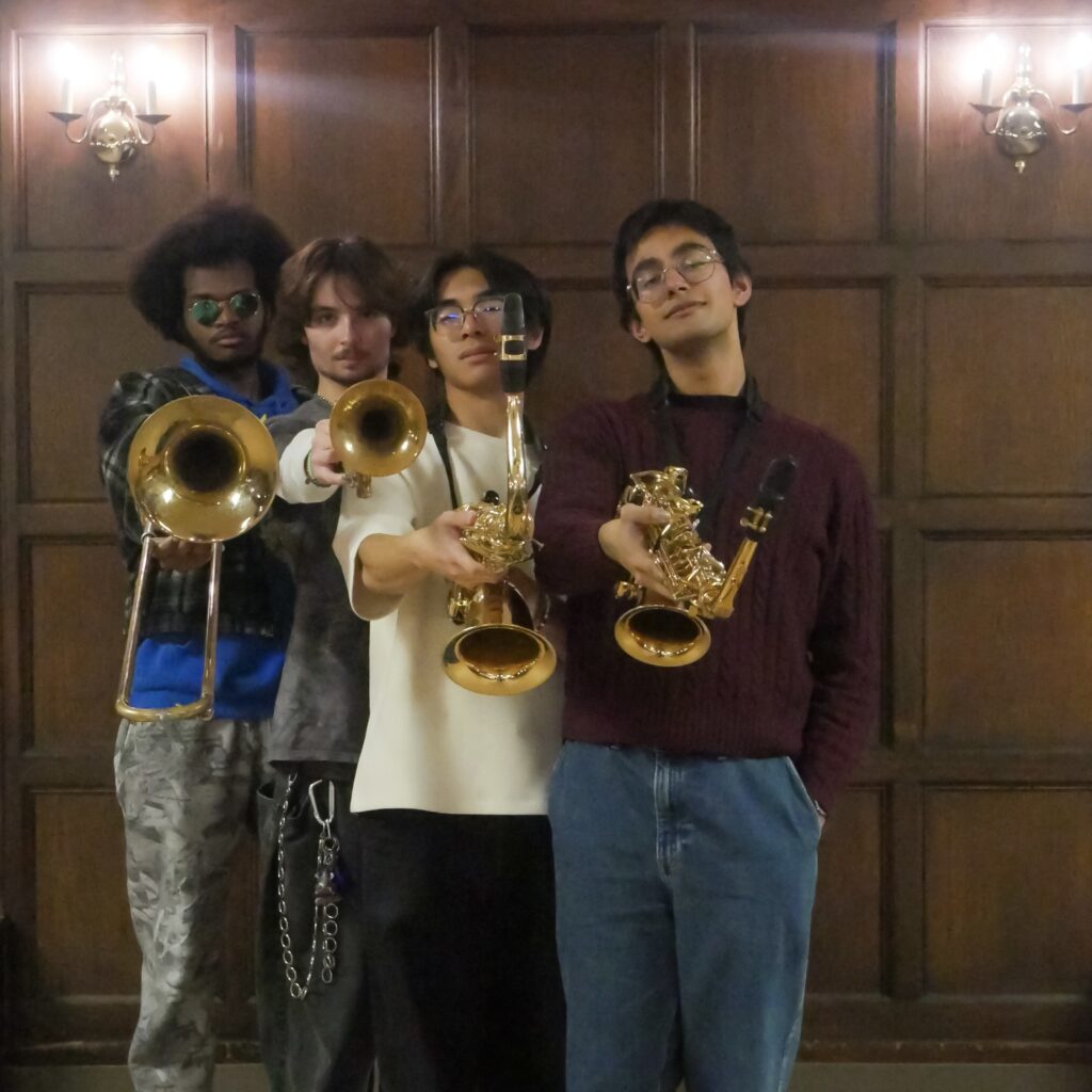 Paratopia's saxophonists, trombonist, and trumpeter posing with their instruments facing the camera.